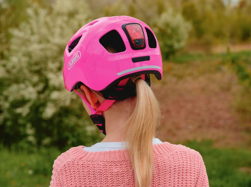 Rear view of a girl wearing the pink YOUN-I 3.0 children’s helmet © ABUS