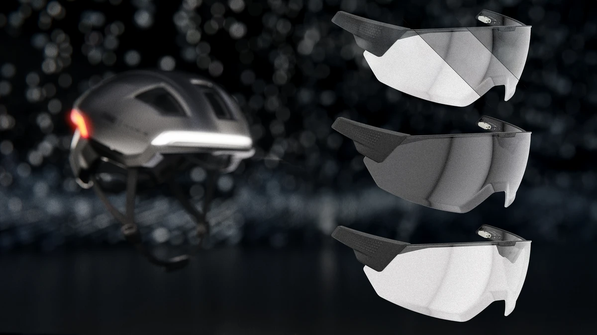 Isolated product shot of the HYP-E urban helmet with three matching visors in different tints in the foreground © ABUS