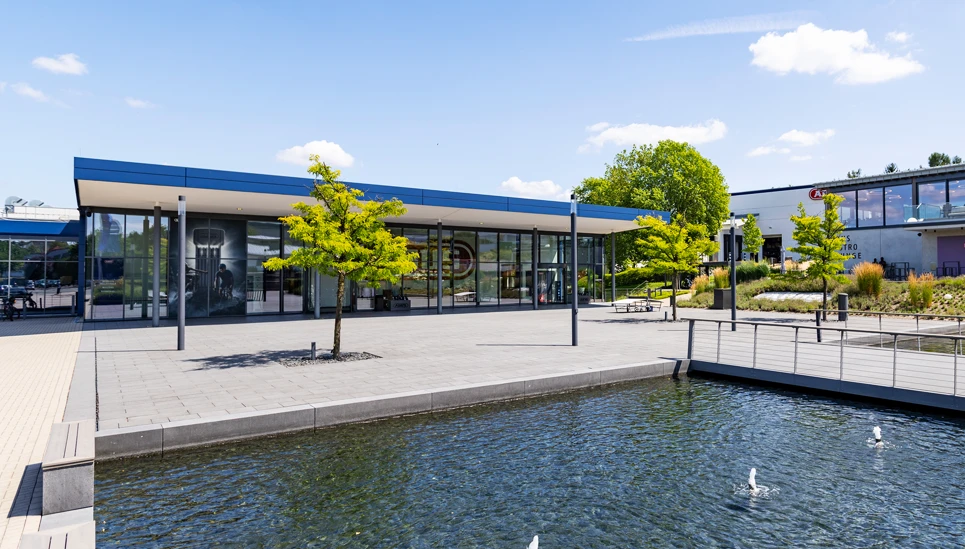 Außenansicht des ABUS Standorts in Wetter (Ruhr). Modernes Gebäude mit Glasfassade und Teich © ABUS