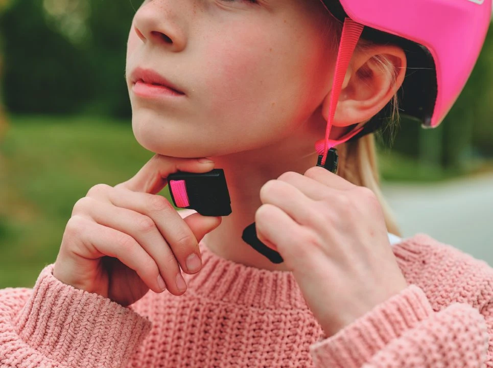Close-up of a girl fastening the Fidlock fastening on the YOUN-I 3.0 children’s helmet © ABUS