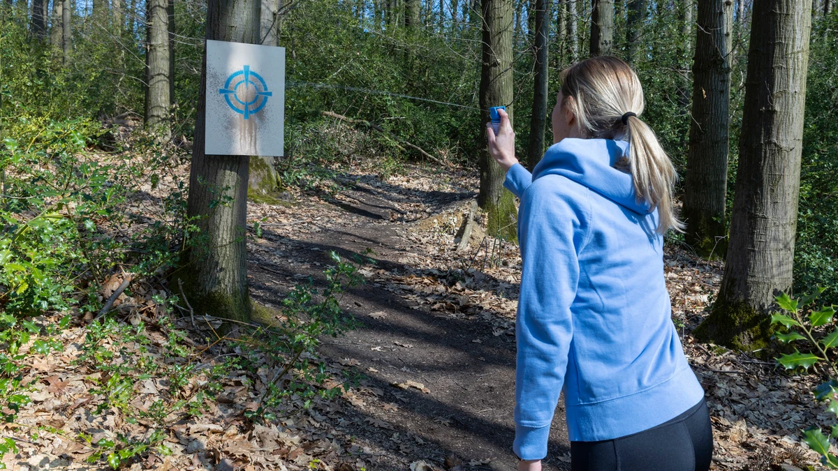 Frau testet mit dem Trainingsspray an einer Zielscheibe © ABUS