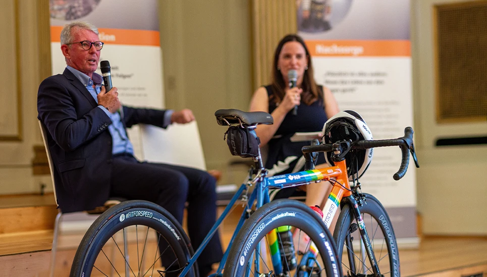 Podiumsgespräch bei savemybrain mit Rennrad und Helm im Vordergrund © ABUS