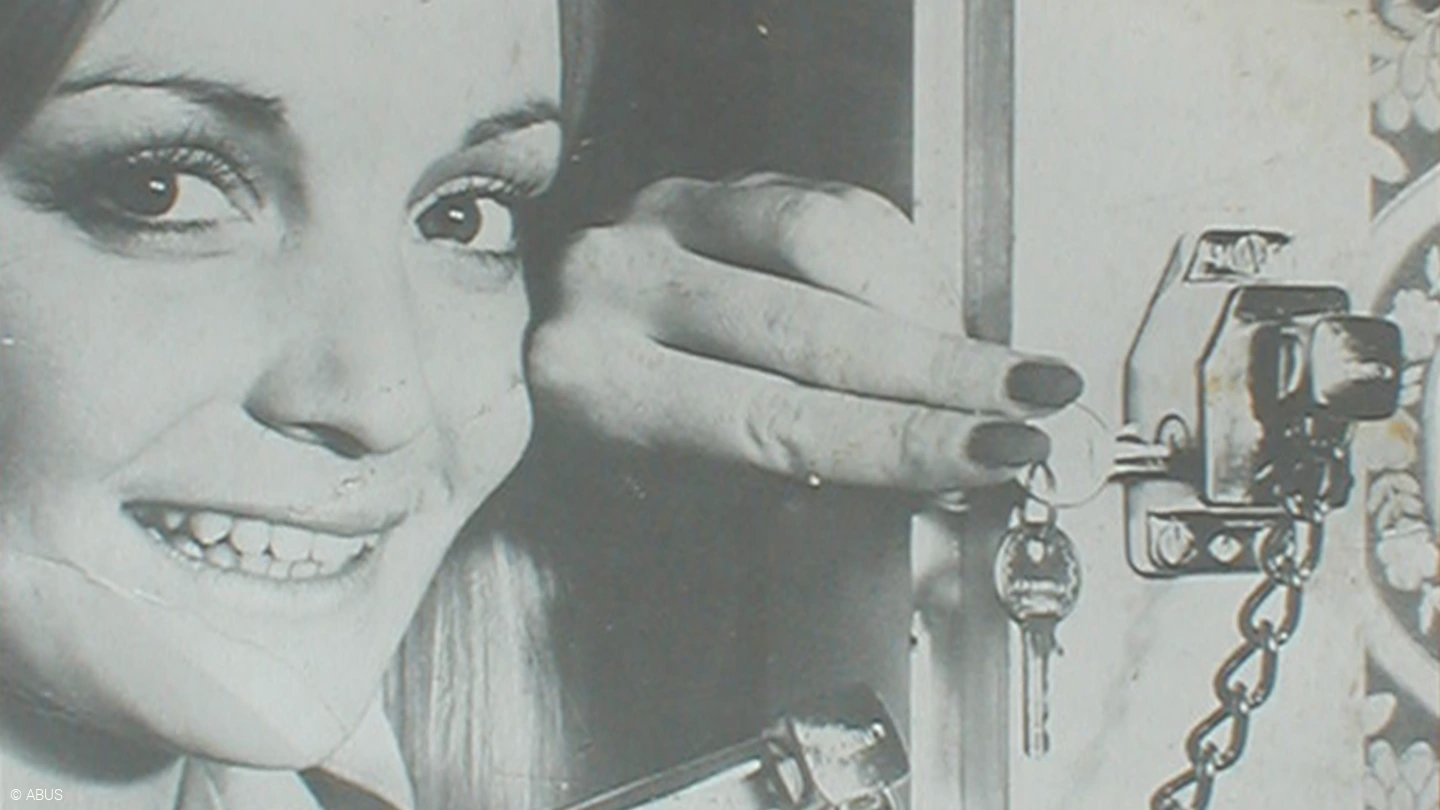 Une femme qui verrouille une serrure supplémentaire de porte © ABUS