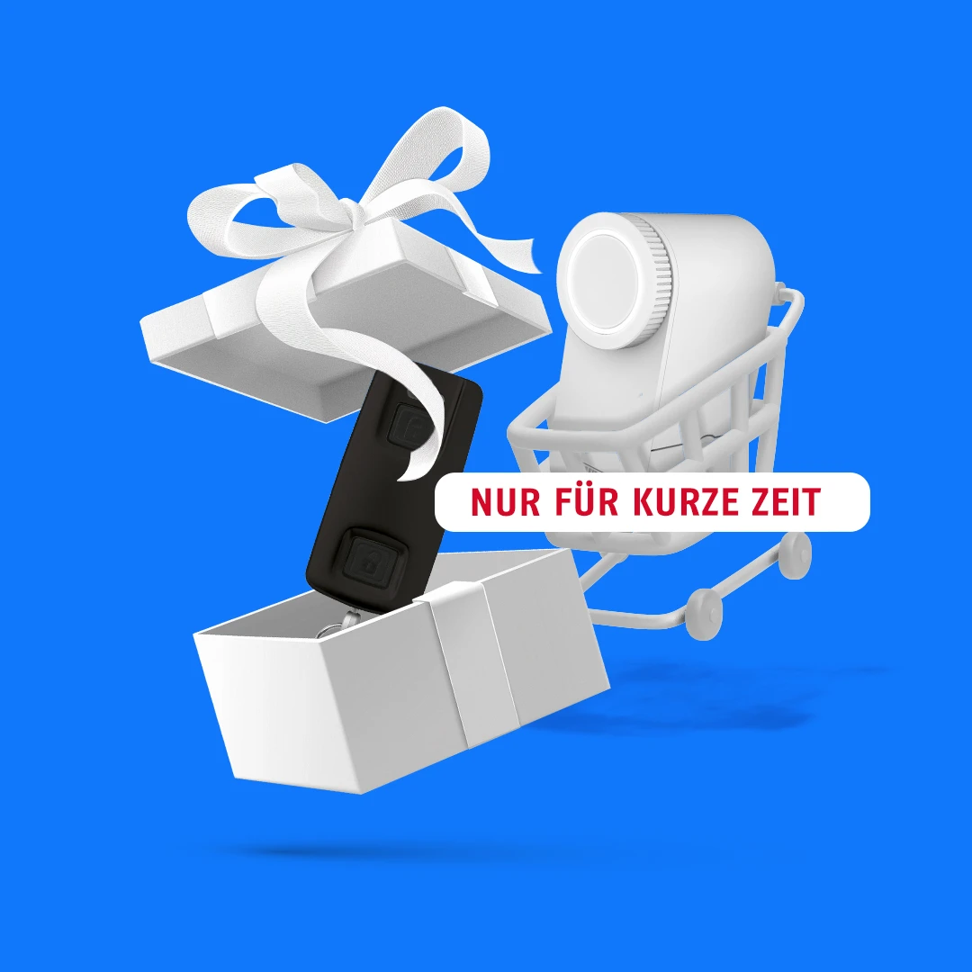 LOXERIS in einem Einkaufswagen und davor eine geöffnete Geschenkbox, in der eine Fernbedienung ist © ABUS