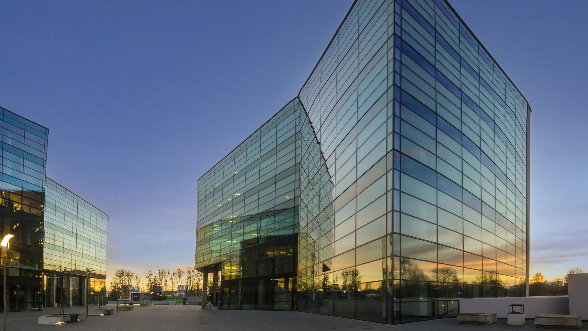 Blick auf ein modernes, vollständig verspiegeltes Bürogebäude.