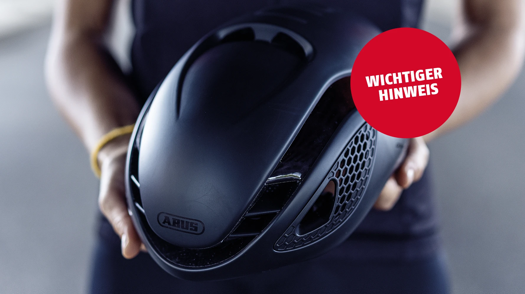 Schwarzer ABUS GameChanger Rennradhelm wird von einer Person in den Händen gehalten ©ABUS