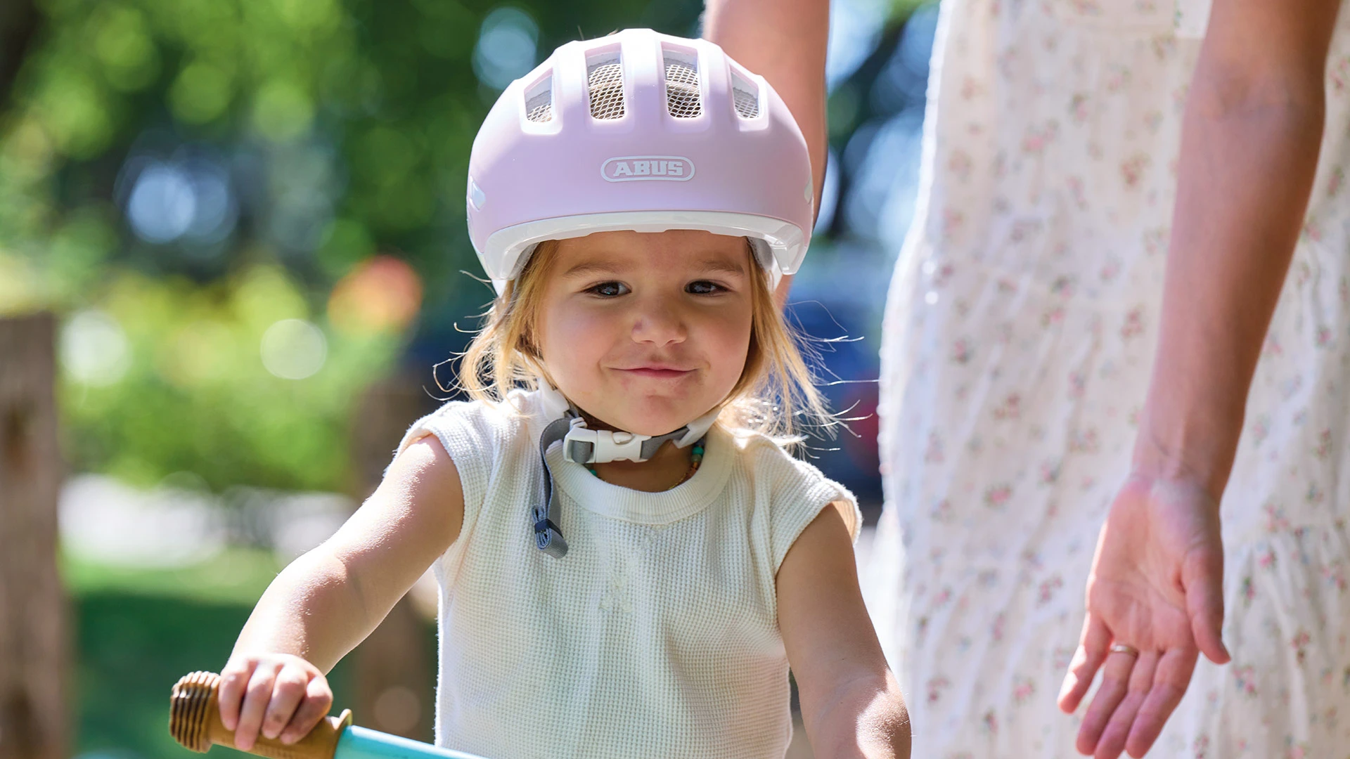 Ein kleines Mädchen fährt mit ihrem Laufrad und trägt den Smiley 3.0 Pure Rosé. ©ABUS