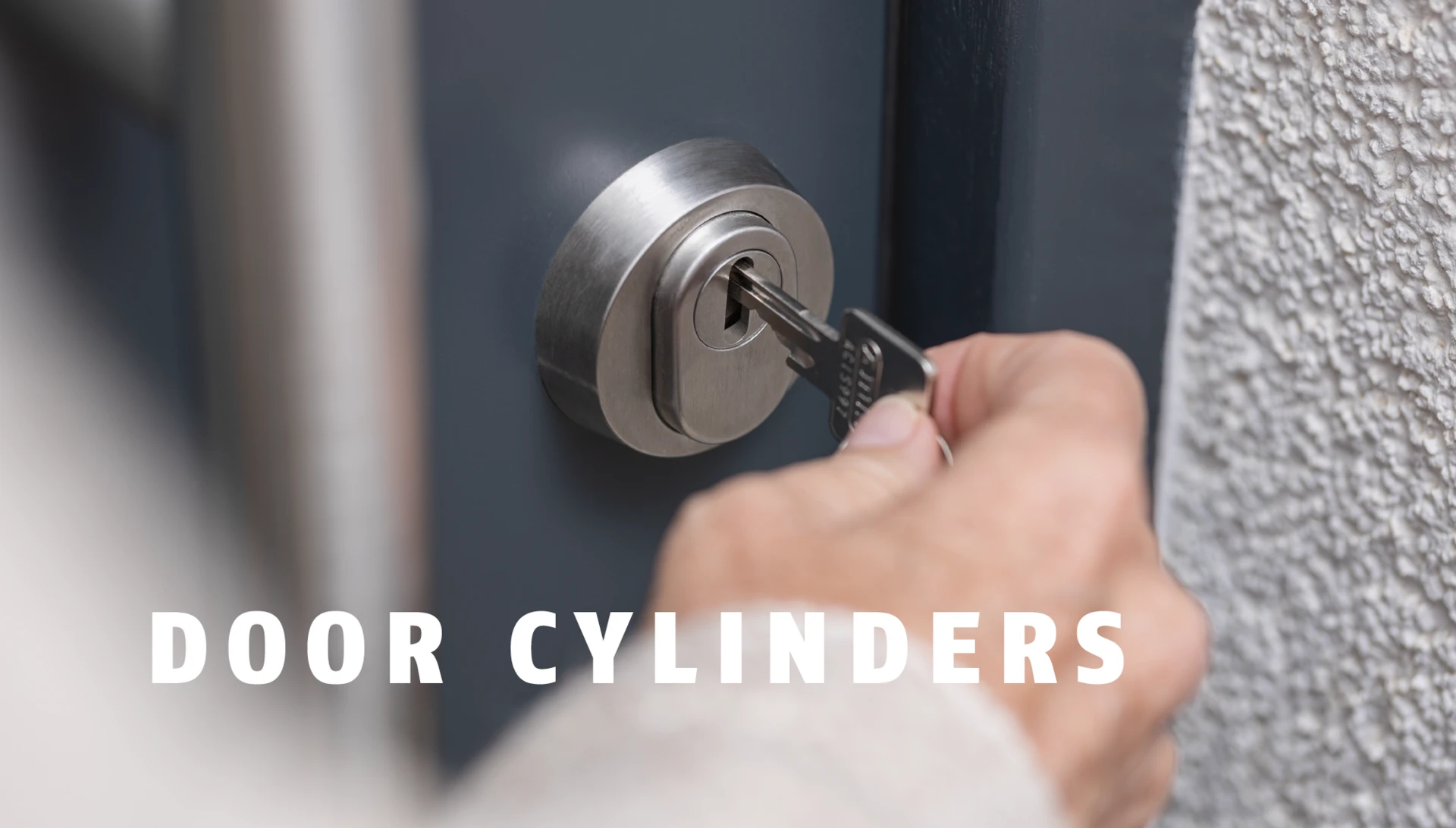 Hand inserts an ABUS key into a modern door lock © ABUS