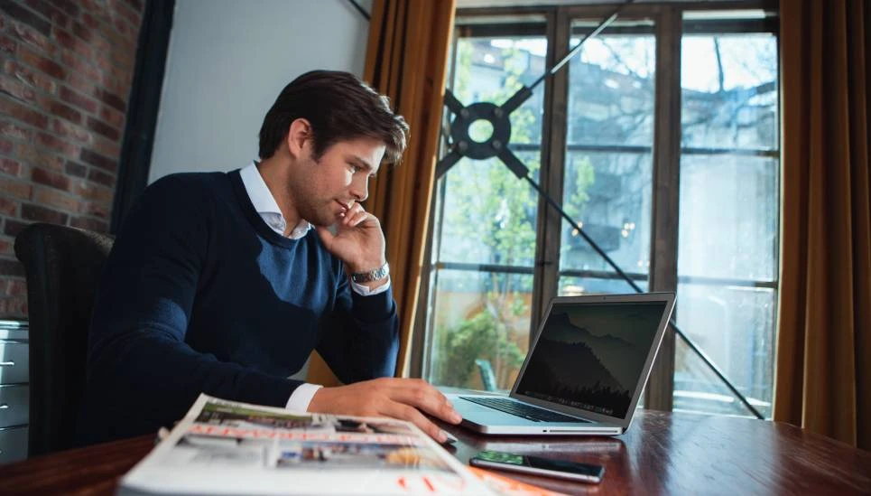 Mann sitzt an einem Tisch im homeoffice und arbeitet am Laptop © ABUS