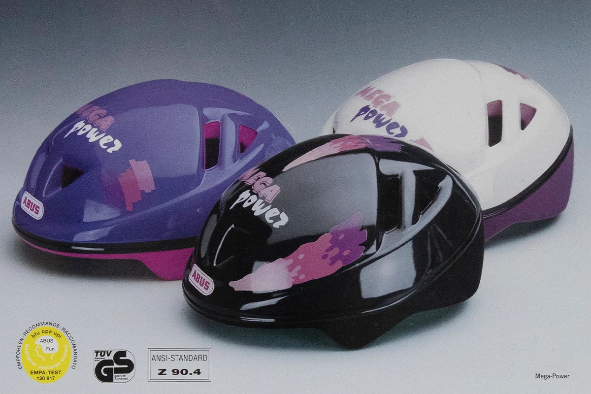Une version bleue, une version rose et une version noire du casque de vélo ABUS Mega-Power pour les jeunes © ABUS