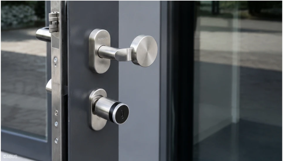 TECTIQ Zylinder in Edelstahl an der modernen Eingangstüre des Geschäftsgebäudes. ©ABUS
