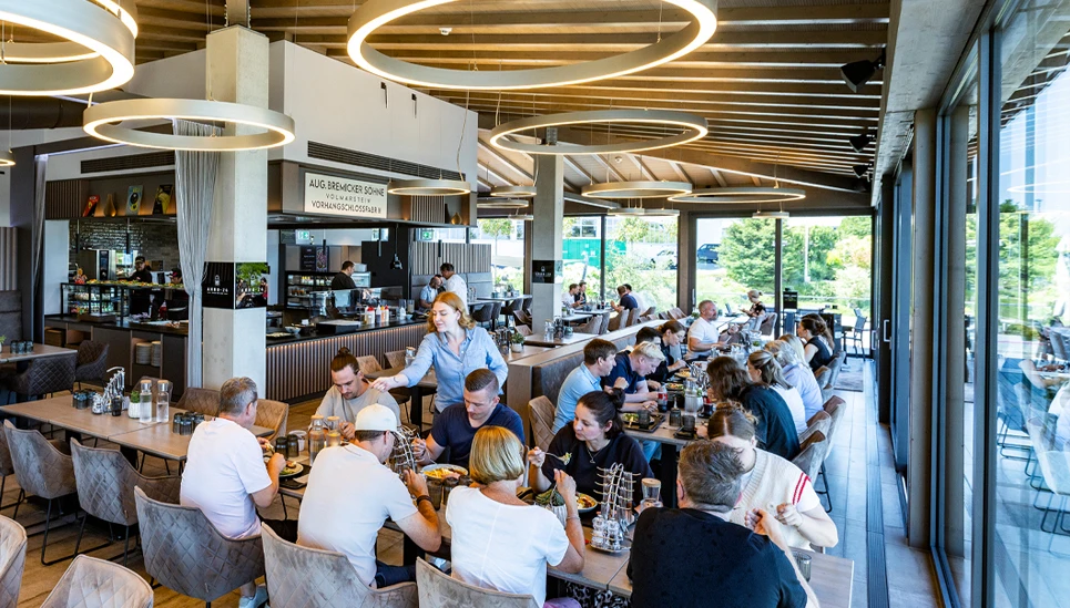 Mitarbeiter sitzen beim Mittagessen im eigenen modernen Restaurant © ABUS