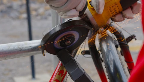 Una smerigliatrice angolare a batteria che taglia faticosamente l'antifurto ad arco GRANIT Super Extreme 2500. ©ABUS