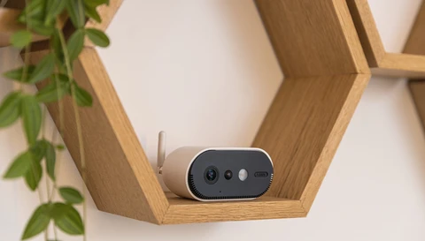 Die Akku Kamera Pro in einem Holzregal: die Kamera ist flexibel platzierbar und fügt sich unauffällig ins Wohnambiente ein.