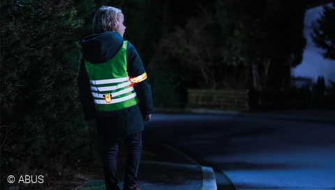 Beschermd tegen de regen en goed zichtbaar in het donker in de buggy - dankzij de TESSA regenhoes © ABUS