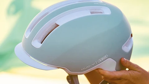 ABUS HUD-Y Urban-Helm in Pure Mint, seitliche Ansicht in der Hand gehalten © ABUS