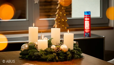 Entspannt durch die Adventszeit mit dem Feuerstopp neben dem Adventskranz © ABUS
