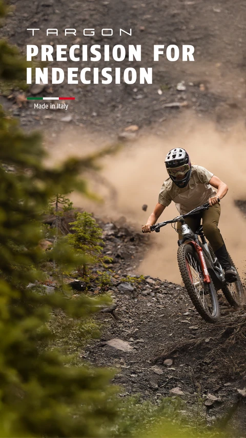 A mountain biker rides downhill on a rocky trail wearing the Targon MTB helmet. Campaign slogan: “Precision for Indecision” © ABUS