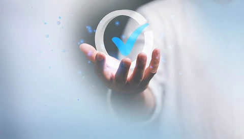Spunta digitale di conferma in mano su uno sfondo sfocato, ideale di successo e approvazione nel settore tecnologico. ©shutterstock