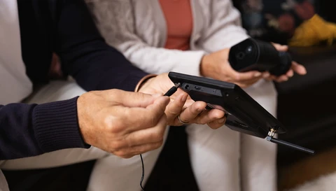 Ein Mann steckt ein Kabel an einem Monitor des ABUS EasyLook Basicsets an.