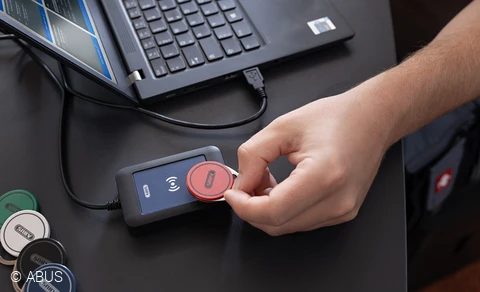 Hand hält Chip an Lesegerät