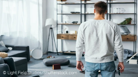 Ein Mann in einem Raum, in dem alle Gegenstände durcheinander sind © Light Field Studios/Shutterstock.com