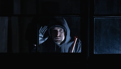 Einbrecher späht durchs Fenster