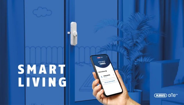 Hand holding smartphone with ABUS One app in front of patio door with WINTECTO ONE in blue living environment. © ABUS