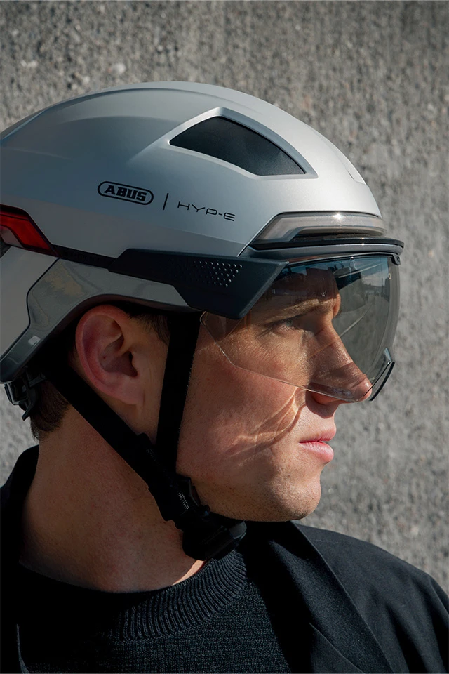 Zijaanzicht van een man die de HYP-E ACE-fietshelm met geïntegreerd vizier draagt © ABUS