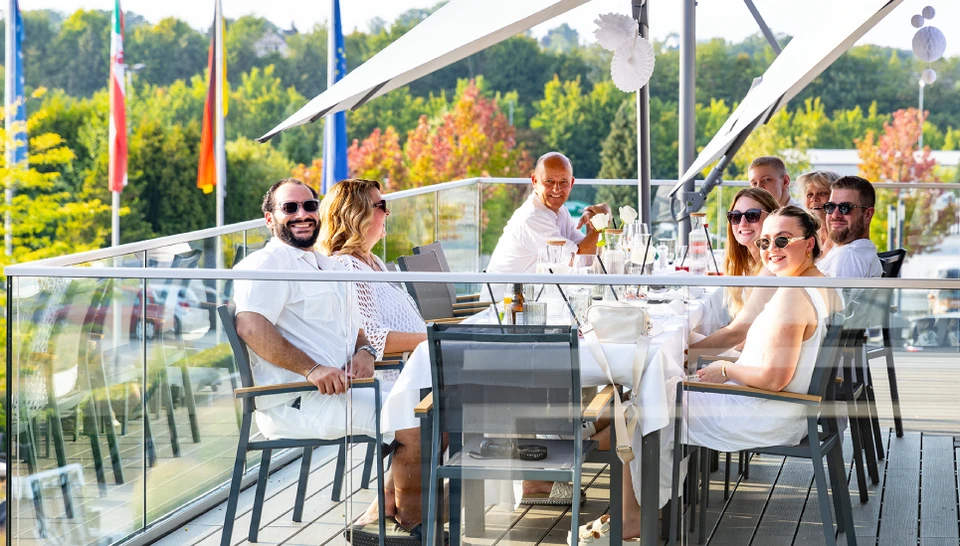 Mitarbeiter sitzen beim Familienbrunch am Tisch und lächeln © ABUS