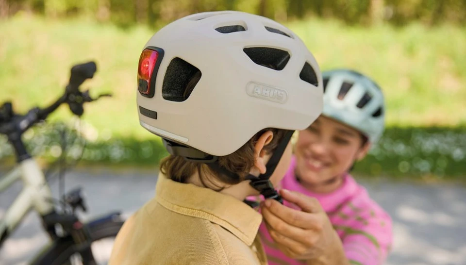 Side view of a child wearing a YOUN-I 3.0 bicycle helmet in powder beige © ABUS
