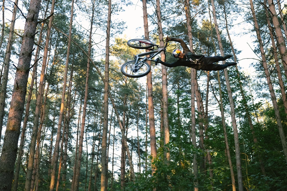 Rowerzysta górski Szymon Godziek wykonuje spektakularny skok w lesie © ABUS