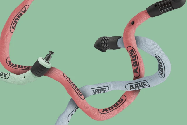 Coffre-fort à chaîne 6807C avec revêtement textile, chaînes entrelacées rouges et bleu clair sur fond vert © ABUS