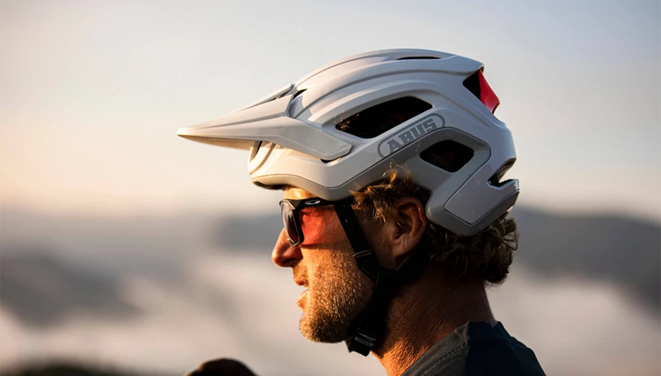 Athlet Richie Schley mit Sonnenbrille und einem weißen ABUS Cliffhanger Helm © ABUS