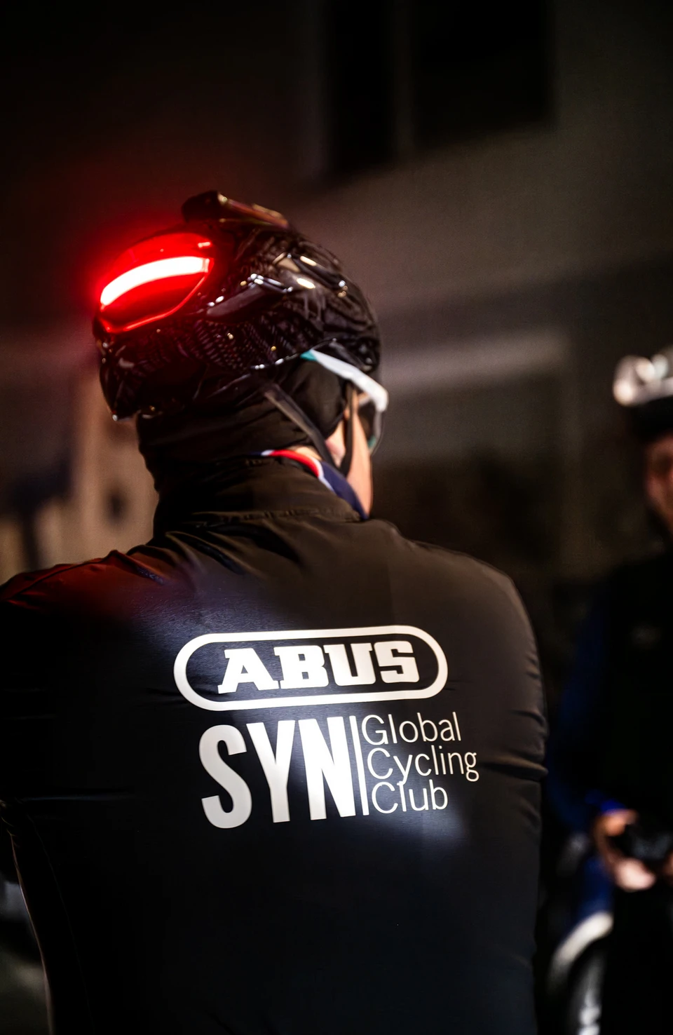 Close-up of a Taipan LED with integrated rear light during a night-time ride © ABUS