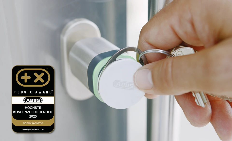 Eine Hand hält einen Chip an einen wAppLoxx-Zylinder, links das Logo des Plus X Awards