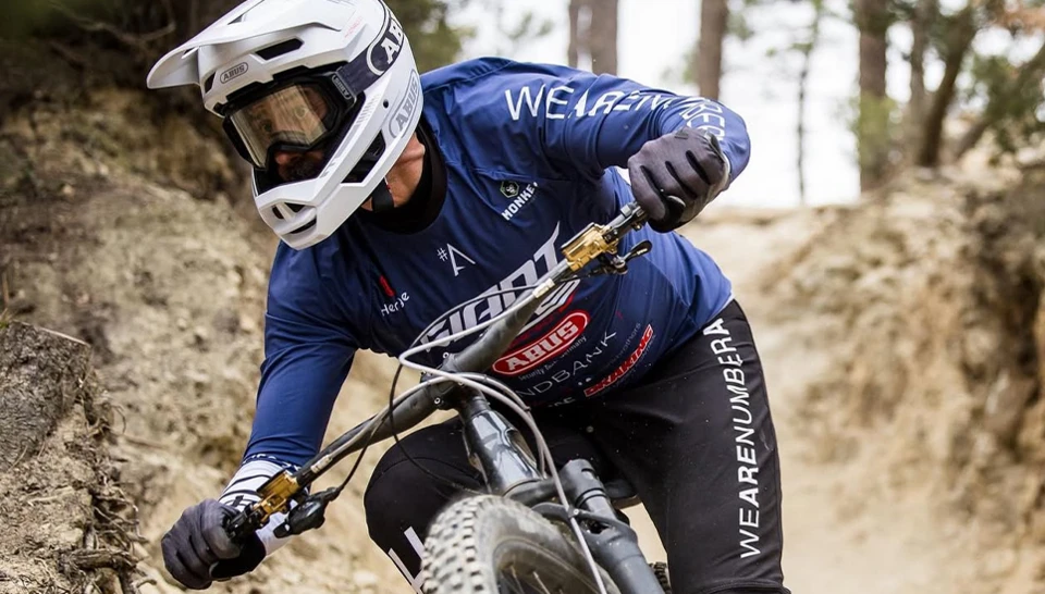 Athlet Cerdic Gracia auf einem Mountainbike mit weißem ABUS Helm © ABUS