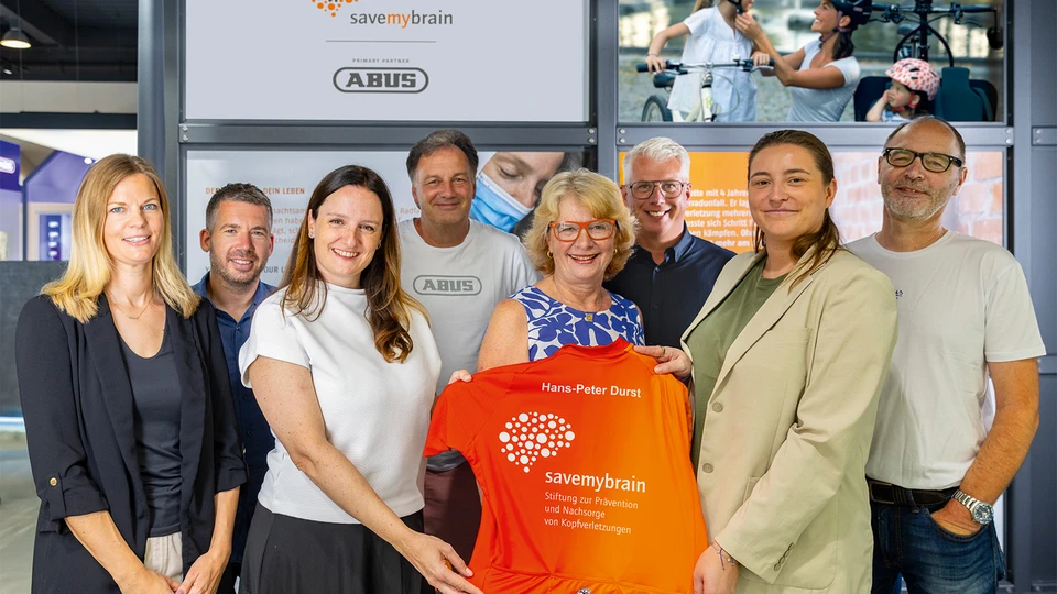 Gruppenfoto von Vertreterinnen und Vertretern der Stiftung savemybrain sowie von ABUS vor der savemybrain-Ausstellung bei ABUS © ABUS
