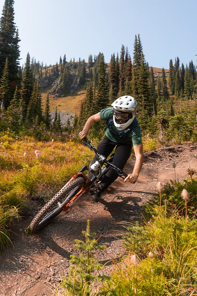 Mountainbiker rijdt over een smal, rotsachtig pad en draagt daarbij de MTB-fietshelm Targon © ABUS