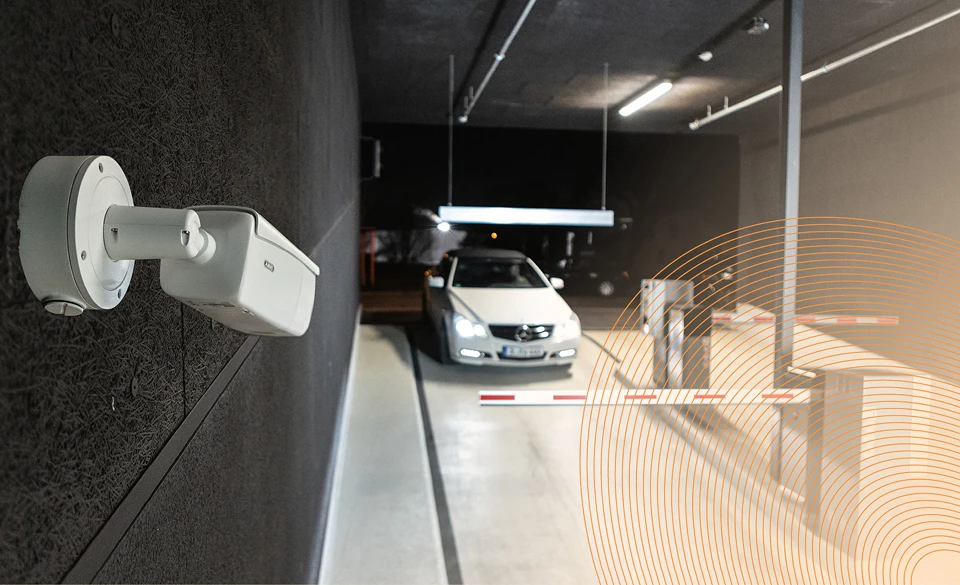 Aufnahme eines Autos an einer Parkschranke; eine ABUS-Kamera ist auf das Fahrzeug gerichtet, um das Kennzeichen zu erkennen.